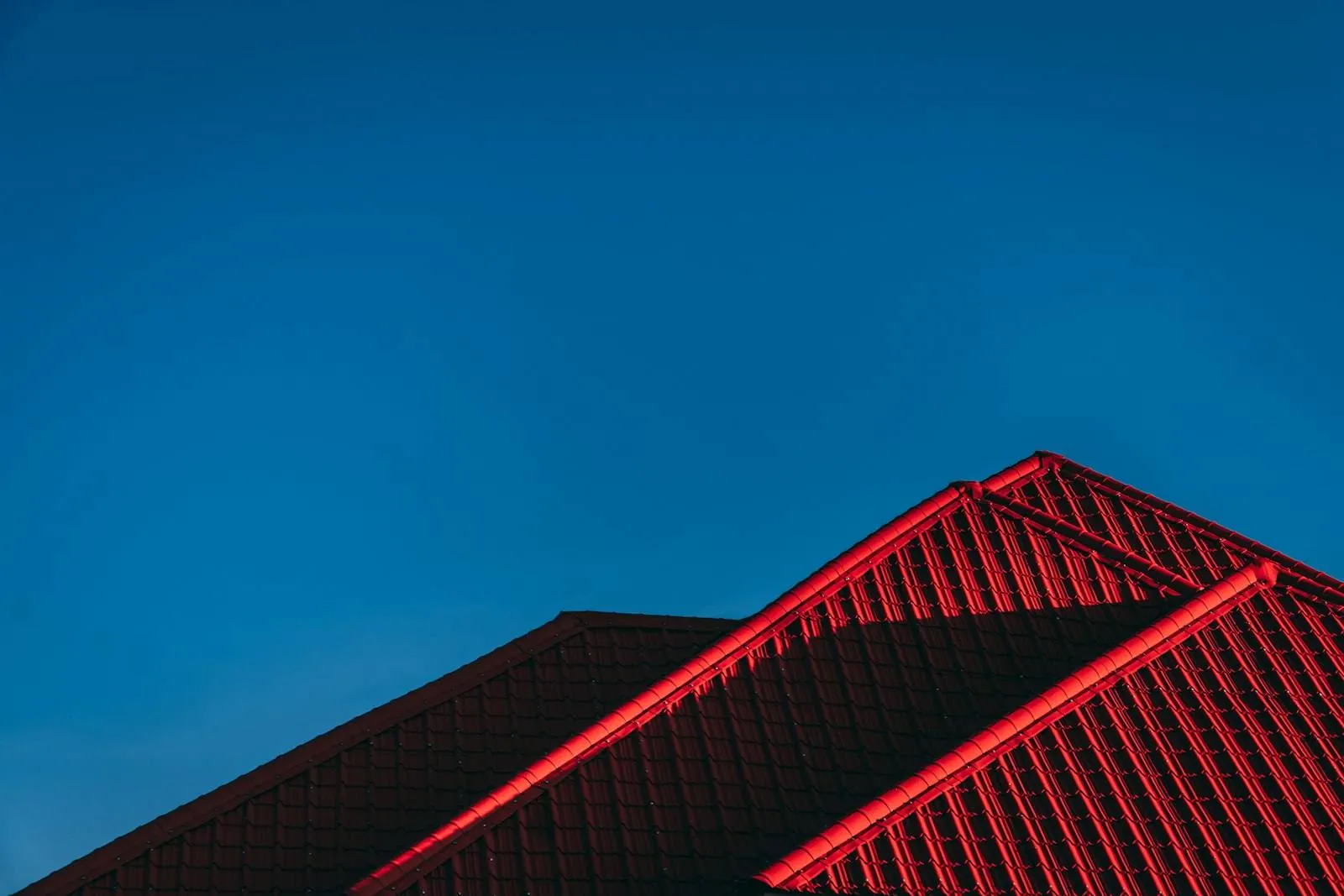 Mörkrött plåttak mot blå himmel